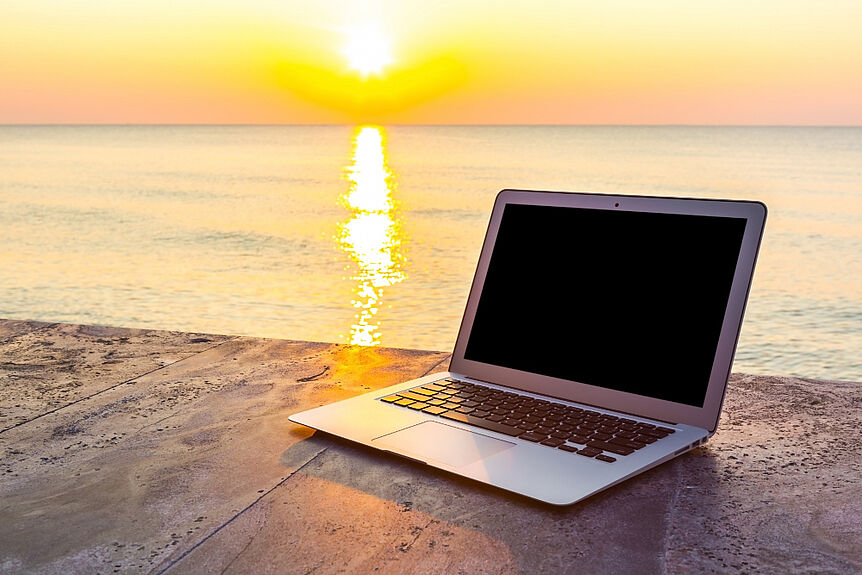 Free Photo-Laptop on stone surface and sea background